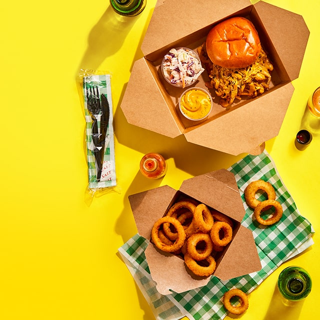 Sandwich au porc barbecue accompagné de rondelles d’oignon